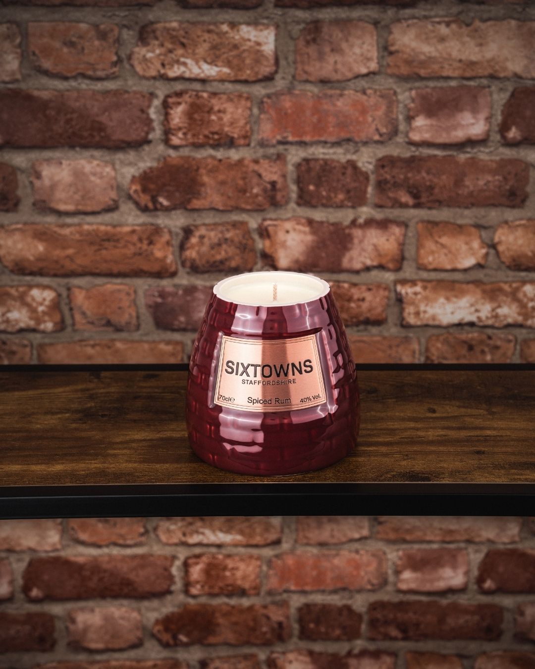 SIXTOWNS Spiced Rum in deep burgundy ceramic bottle on bar background